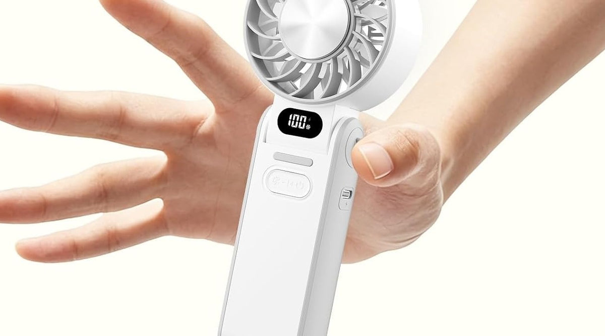 White fan held in hand, showing scale